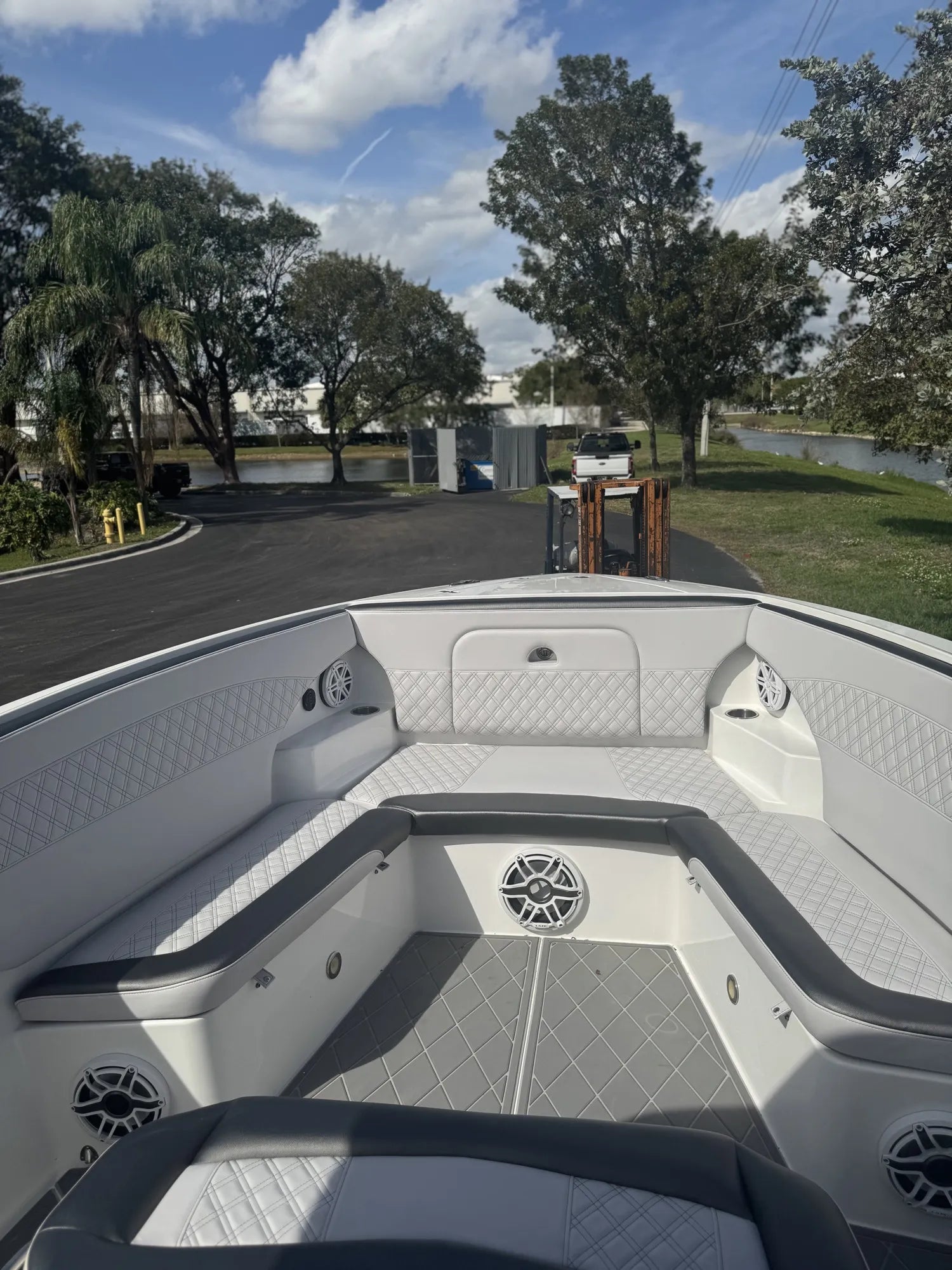 Nor-Tech bow seating in white diamond-stitch vinyl with grey bolsters, JL Audio speakers and matching diamond EVA flooring