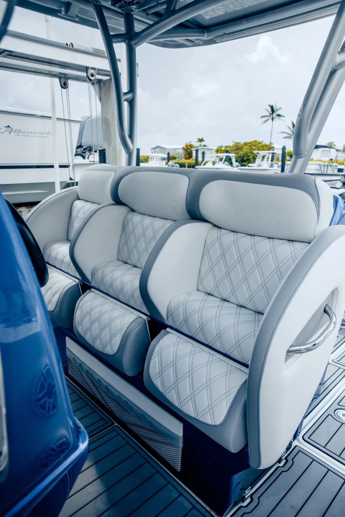 Helm bench and flip bolsters in white diamond-stitch vinyl under a hardtop, on a blue Nor-Tech center console