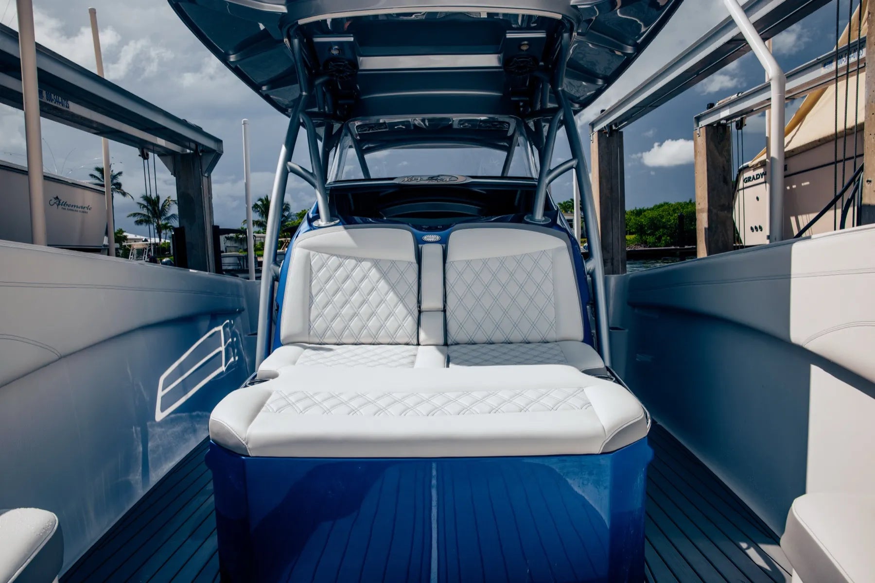 Double helm seat with flip bolsters in white diamond-stitch vinyl, seen from the bow of a blue Nor-Tech